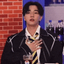 a man in a suit and tie is holding a glass of pepsi