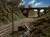 a train track with a bridge in the background and a black box in the foreground