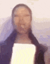 a blurry picture of a woman holding a piece of paper in her hand .