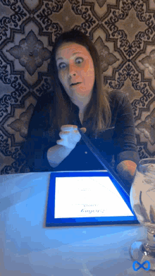 a woman sitting at a table looking at a menu that says " enigma " on it