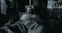 a man in a white shirt is making a funny face in a dark room .