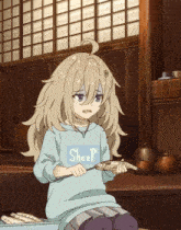 a girl wearing a sweater that says sheep holds a fish