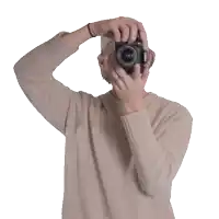 a man wearing a hat is holding a camera and smiling
