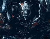 a close up of a metal mask with a sword in its mouth