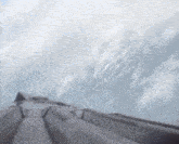 a roller coaster going up a hill with a cloudy sky in the background