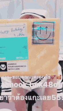 a person holding a box that says happy birthday is mine on it