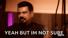 a man in a suit and tie is making a funny face and saying `` yeah but i 'm not sure '' .