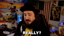 a man with a beard and mustache is sitting in front of a computer and says `` really '' .
