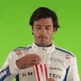 a man in an atlassian williams racing jacket is holding a packet of popcorn