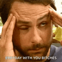 a man with a beard is holding his head with his hands and says `` everyday with you bitches '' .