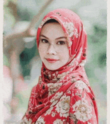 a woman wearing glasses and a red floral hijab