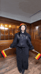 a woman in a diva sweatshirt holds flags in her hands
