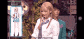 a girl with blonde hair and a blue tie is standing next to a boy in a suit .