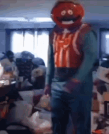 a person in a tomato mask is standing in a living room .
