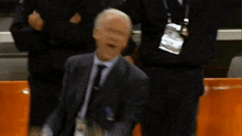 a blurry picture of a man in a suit with a lanyard around his neck that says ' sd ' on it