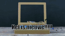 a hand is holding a cardboard box that says het is nieuwe !!!