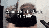 a man wearing a helmet stands in front of a microphone with the words amina koduklarim cs gelin written above him