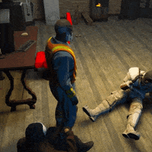 a man in a blue vest stands next to a man laying on the floor