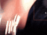 a blurred image of a person 's face with a white arrow pointing to it