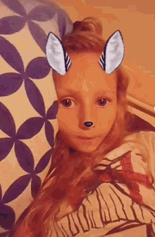 a little girl with a mask on her face looks at the camera