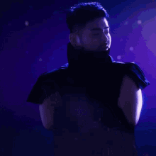a man in a black sleeveless top with a turtleneck looks down