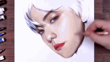 a person is drawing a boy 's face with blue eyes and red lips .