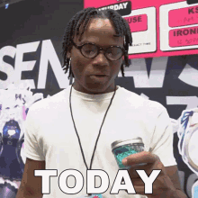 a man wearing glasses and a lanyard holds a cup that says today on it