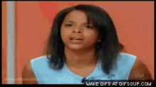 a woman in a blue shirt is making a funny face in a gif