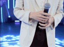 a person in a white jacket is holding a microphone in their hand .