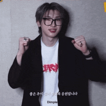 a young man wearing glasses and a t-shirt with the word dimple on it .