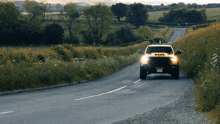 a yellow truck driving down a country road with a license plate that says ' jcj ' on it