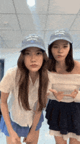 two girls wearing hats that say " almost almost " are posing for a photo