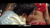 a man is kissing the belly of a woman in a red saree .
