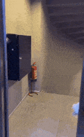 a red fire extinguisher is hanging on a wall next to a staircase