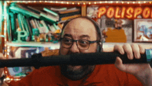 a man wearing headphones is holding a stick in front of a sign that says polispa