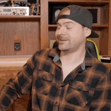 a man wearing a plaid shirt and a hat with the number 10 on the back