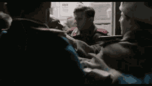 a man is pointing a gun at another man while another man tries to stop him .