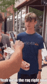 a boy wearing a quiksilver shirt is getting ice cream