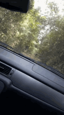 a close up of a car dashboard with a few trees in the background