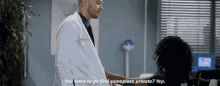 a man in a white coat is shaking hands with a woman in a room .