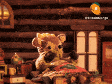 a teddy bear is sitting on a bed next to a sign that says bitcoinmango_