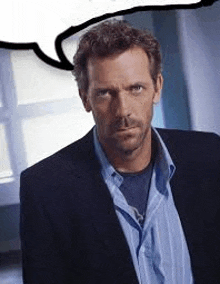 a man in a suit and blue shirt is standing in front of a window with a speech bubble above him .