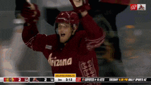 a hockey player in a arizona jersey celebrates his goal