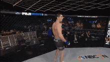 a fighter in a cage with a nbc n logo on the floor