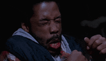 a man with a beard has his mouth open and his hands outstretched