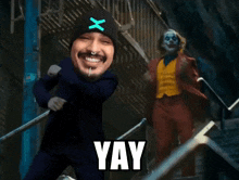 a man wearing a beanie with the letter x on it is dancing next to a clown in a suit that says yay
