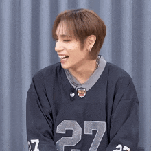 a young man wearing a black jersey with the number 27 on it