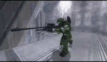 a man in a green armor is holding a rifle in a video game .