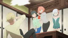 a group of anime characters are standing around a table with a man laying on the floor