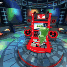 a gummy bear is dancing on a stage with hearts on it